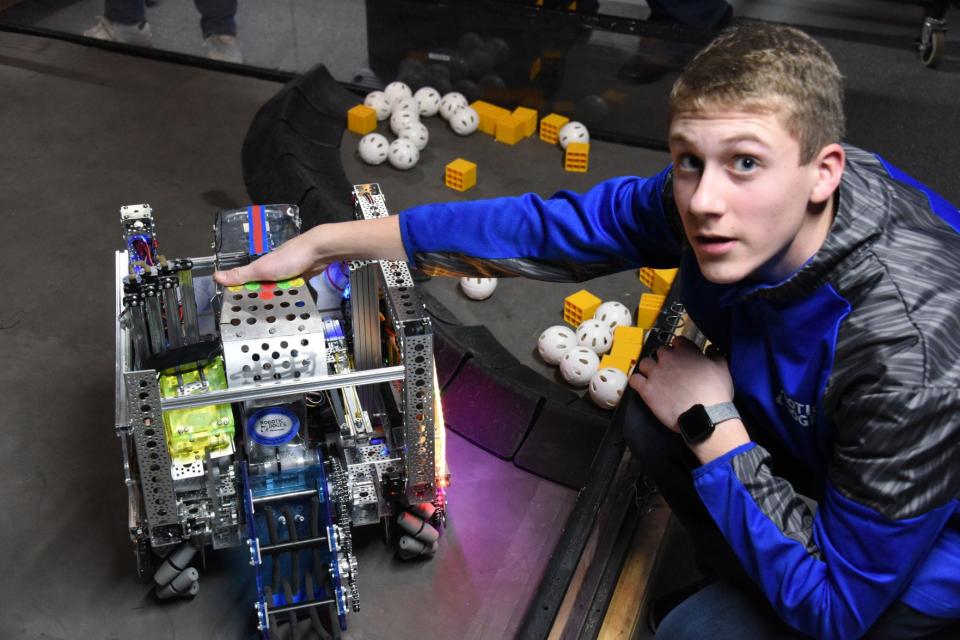 Isaac Metz, a freshman attending Pennsylvania Cyber Charter School in Jennerstown, points out features of the Robotic Doges' robot.