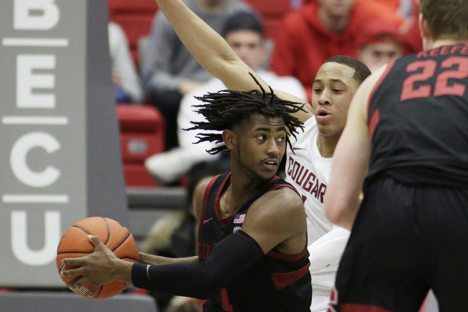 Stanford guard Daejon Davis, left, looks to pass while pressured by Washington State guard Jervae Robinson during the second half of an NCAA college basketball game in Pullman, Wash., Sunday, Feb. 23, 2020. Stanford won 75-57. (AP Photo/Young Kwak)