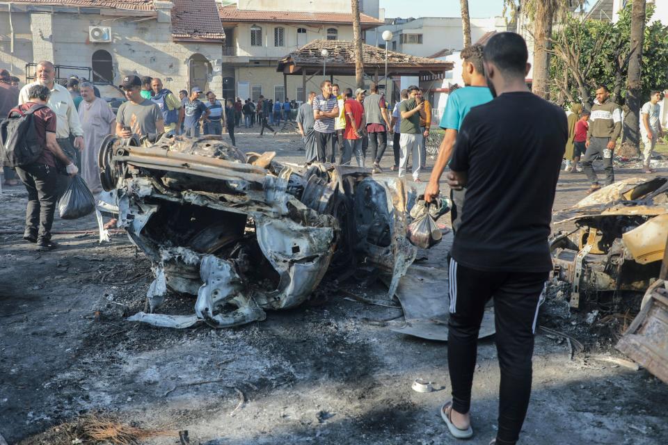 People inspect the damage at al-Ahli hospital in central Gaza on Oct. 18. 