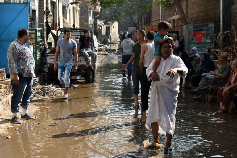 Egyptians walk through a flooded street following a powerful bomb explosion that ripped through the facade of the Italian consulate in Cairo, on July 11, 2015