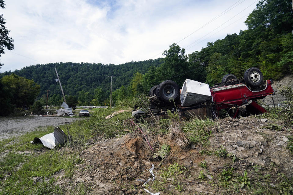 A overturned car is seen after it was swept away in massive flooding Thursday, Aug. 4, 2022, in Lost Creek, Ky. (AP Photo/Brynn Anderson)