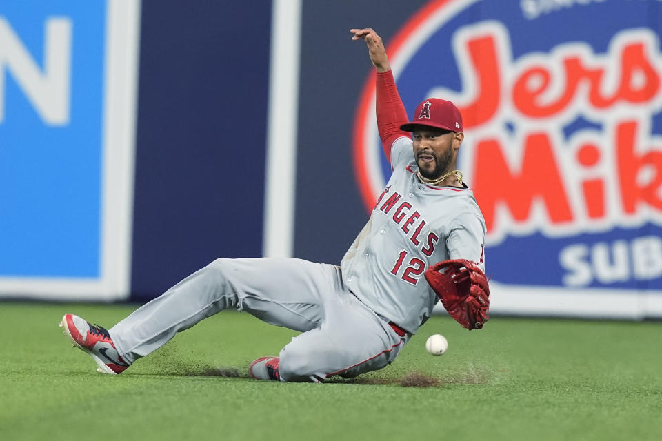 Los Angeles Angels center fielder Aaron Hicks (12) is late to catch a hit by Miami Marlins' Bryan De La Cruz (14) during the sixth inning of a baseball game, Wednesday, April 3, 2024, in Miami. The Angels defeated the Marlins 10-2. (AP Photo/Marta Lavandier)