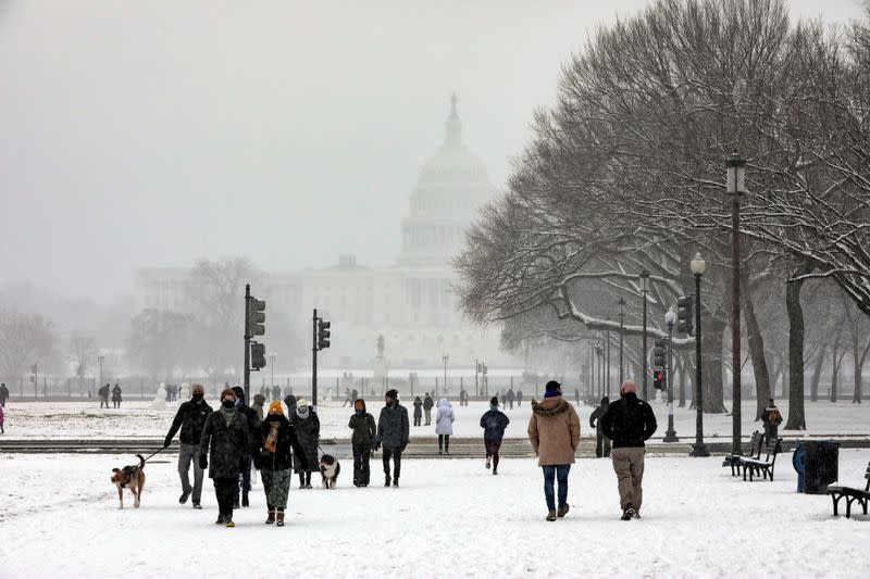 People walk through the snow at the National Mall near the U.S. Capitol in Washington