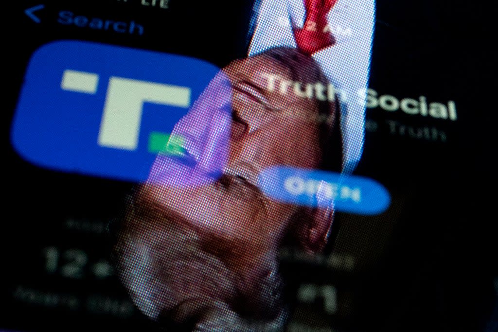 This photo illustration shows an image of former President Donald Trump reflected in a phone screen that is displaying the Truth Social app, in Washington, DC, on February 21, 2022. (AFP via Getty Images)