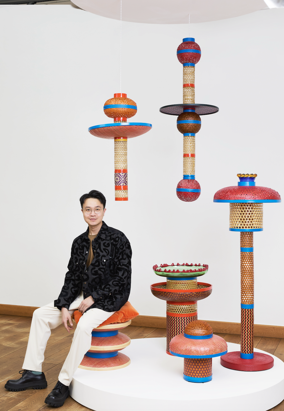 a person sitting on a chair with colorful objects around him