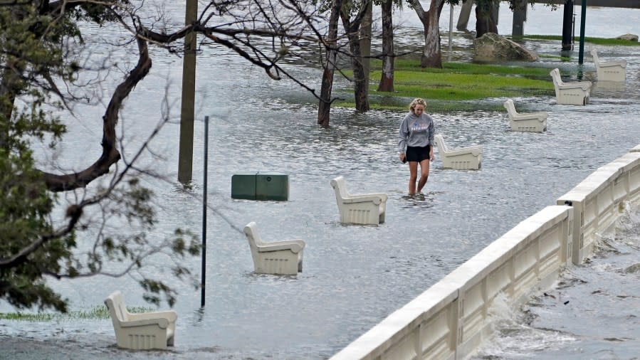 A woman walks through flooded water along Bayshore Blvd., from storm surge from Hurricane Idalia Wednesday, Aug. 30, 2023, in Tampa, Fla. (AP Photo/Chris O’Meara)