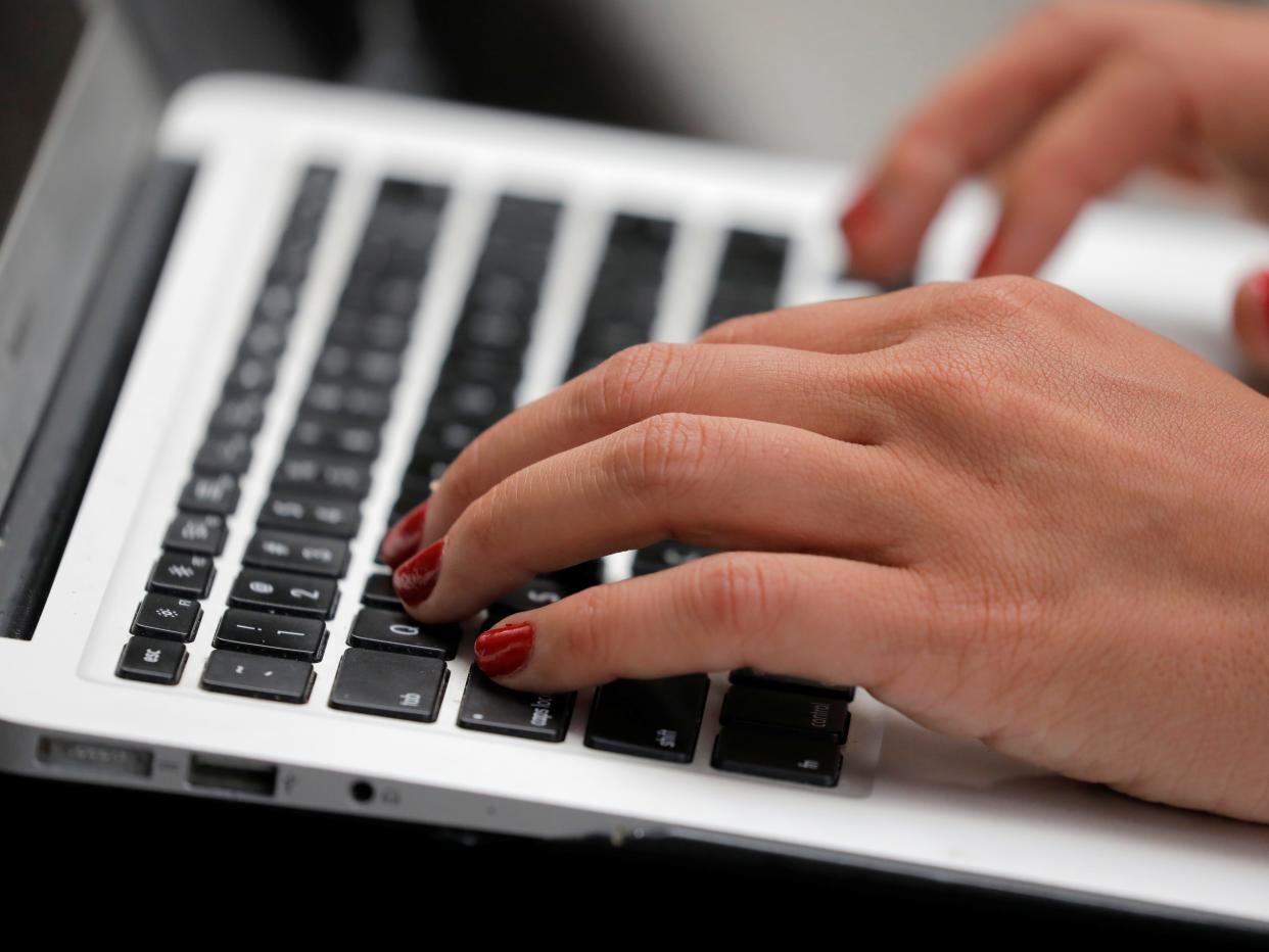 A person types on a laptop computer.