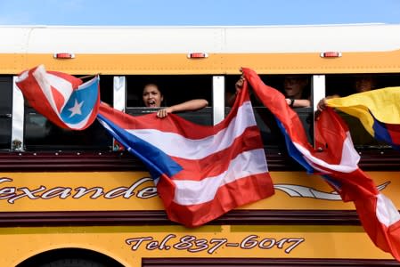 Demonstrators wave Puerto Rican flags out of a bus window during the national strike calling for the resignation of Governor Ricardo Rossello in San Juan