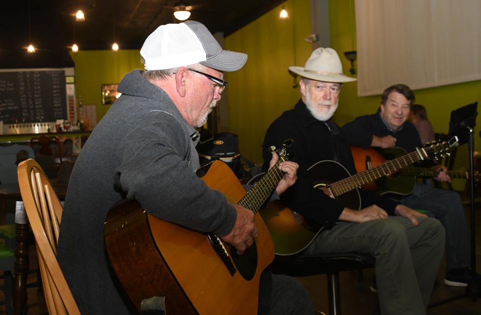 Gene Barton of Pineville (far left) sings as John Jordan (center) and Rick Adams listen during a session of the CenLa Songwriters Circle.