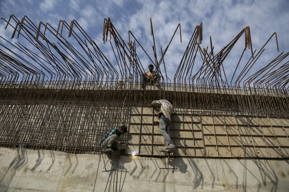 Indian laborers work at a flyover construction site in Jammu, India, Tuesday, Nov. 30, 2021. India’s economy grew by 8.4% in the July-September quarter from the same period a year earlier, the government announced Tuesday, raising hopes of a recovery after the country suffered historic contractions sparked by the coronavirus pandemic. (AP Photo/Channi Anand)