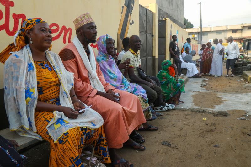 People wait for the opening of a polling office during the presidential election in Abidjan