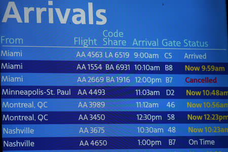 FILE PHOTO: An American Airlines arrivals board displaying American Airlines flight 2669, which was scheduled to be flown by a Boeing 737 Max 8, arriving from Miami to New York City at LaGuardia Airport, is seen as cancelled, in New York, U.S., March 14, 2019. REUTERS/Shannon Stapleton/File Photo/File Photo