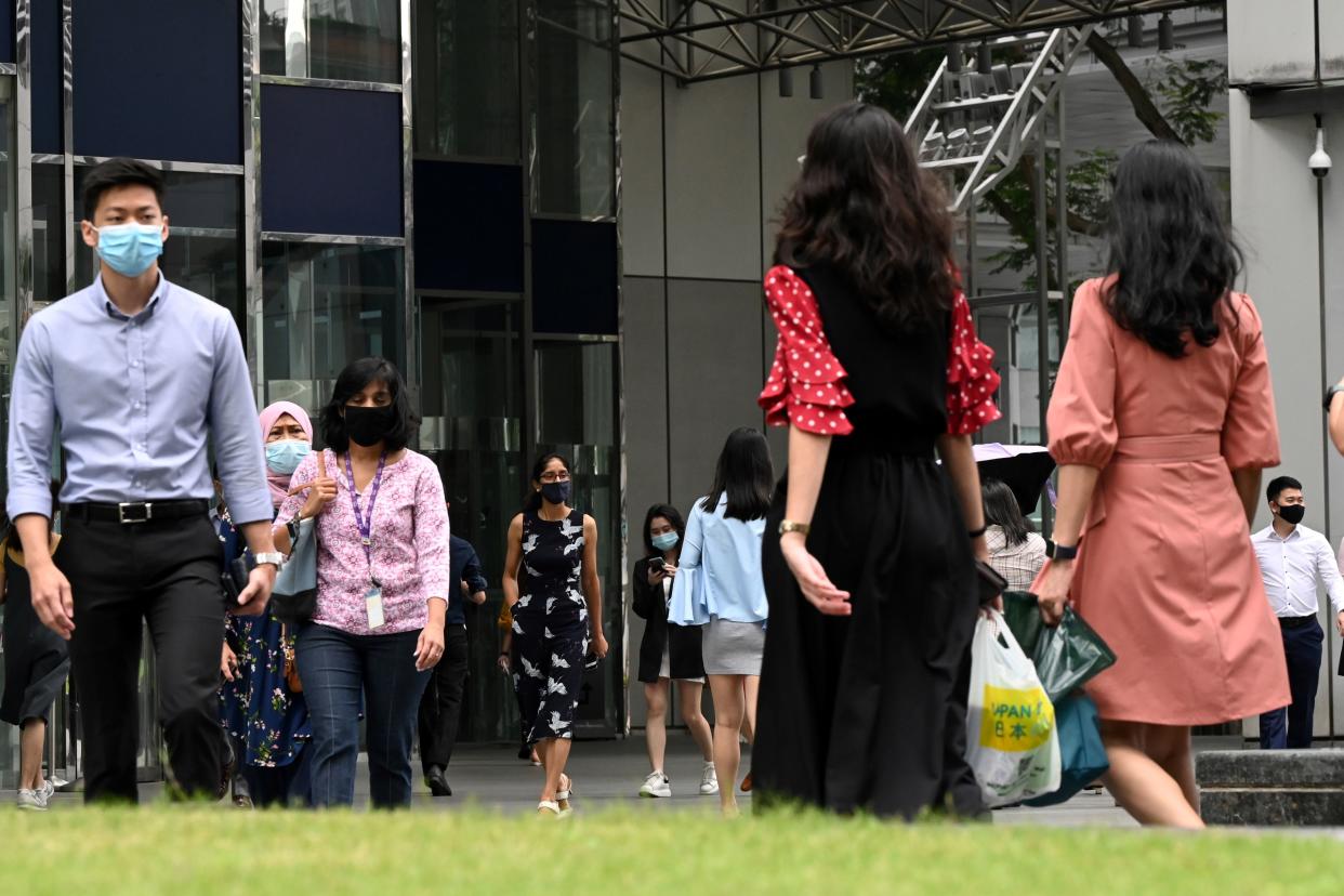 People walk during lunch time at the Raffles Place financial business district  in Singapore on February 16, 2021. (Photo by Roslan RAHMAN / AFP) (Photo by ROSLAN RAHMAN/AFP via Getty Images)