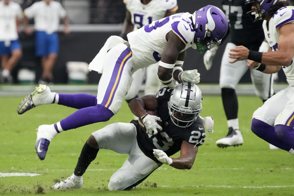 Las Vegas Raiders running back Kenyan Drake is tackled by Minnesota Vikings cornerback Chandon Sullivan during the first half of an NFL preseason football game, Sunday, Aug. 14, 2022, in Las Vegas. (AP Photo/Rick Scuteri)