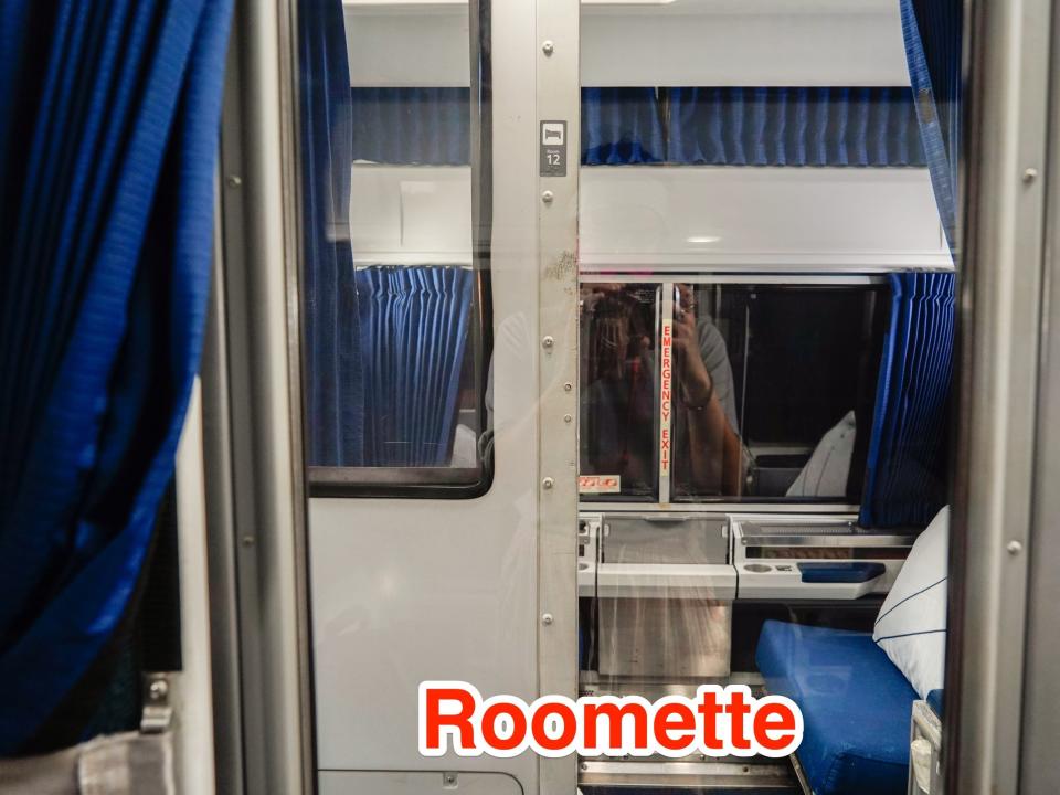 A roomette is seen across the way from another roomette with the door half open