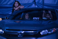 Children watch artists performing at the Estoril Circus rom inside their car despite the coronavirus pandemic in Itaguai greater Rio de Janeiro, Brazil, Saturday, July 18, 2020. Following the measures to curb the spread of the COVID-19, artists of this circus have decided to go back to work in a different way, as a circus drive-in. (AP Photo/Leo Correa)