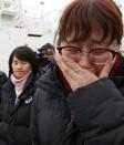 South Korean relatives watch as the damaged Sewol ferry is raised between two barges during a salvage operation off the southwestern island of Jindo, on March 23, 2017