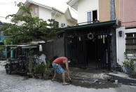 Christopher Bagay, a kitchen crew of the Aida Sol cruise ship in Europe, cleans outside his home upon arriving in Laguna province, south of Manila, Philippines Thursday, May 28, 2020. Bagay said it took him about two months to go through repetitive quarantines in Spain, Germany and Manila before he was finally allowed to go home. Tens of thousands of workers have returned by plane and ships as the pandemic, lockdowns and economic downturns decimated jobs worldwide in a major blow to the Philippines, a leading source of global labor. (AP Photo/Aaron Favila)