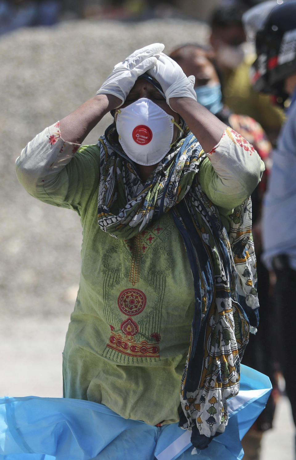 A relative of a person who died of COVID-19 reacts at a crematorium in Jammu, India, Sunday, April 25, 2021. India’s crematoriums and burial grounds are being overwhelmed by the devastating new surge of infections tearing through the populous country with terrifying speed, depleting the supply of life-saving oxygen to critical levels and leaving patients to die while waiting in line to see doctors. (AP Photo/Channi Anand)