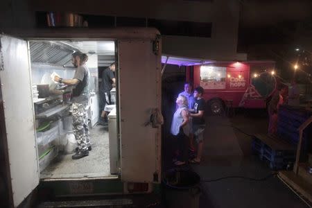 People wait for their food at a food truck in San Juan, Puerto Rico, November 3, 2016. REUTERS/Alvin Baez