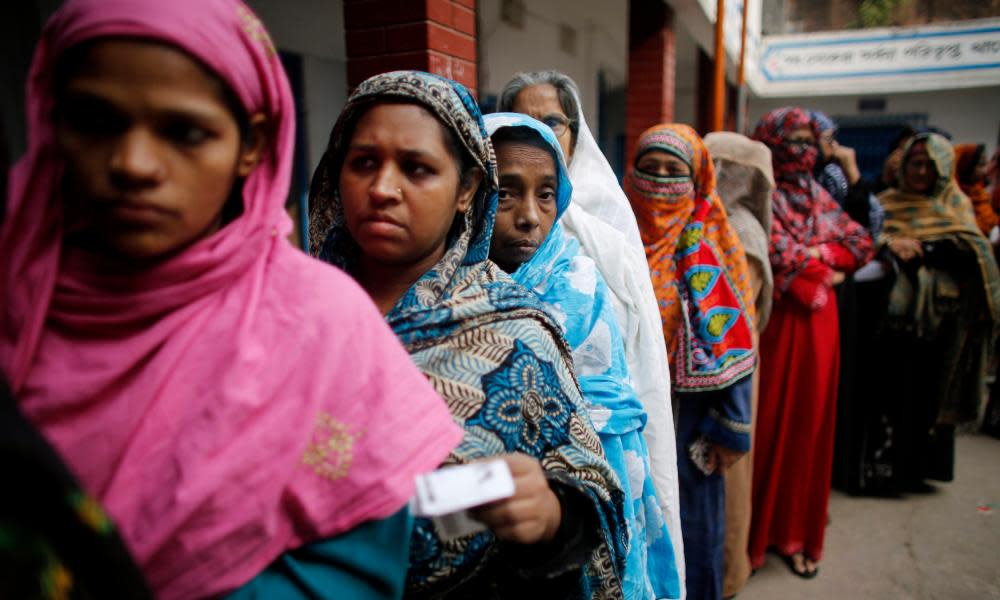 Women stand in line to cast their vote in parliamentary elections in Dhaka on 5 January 2014