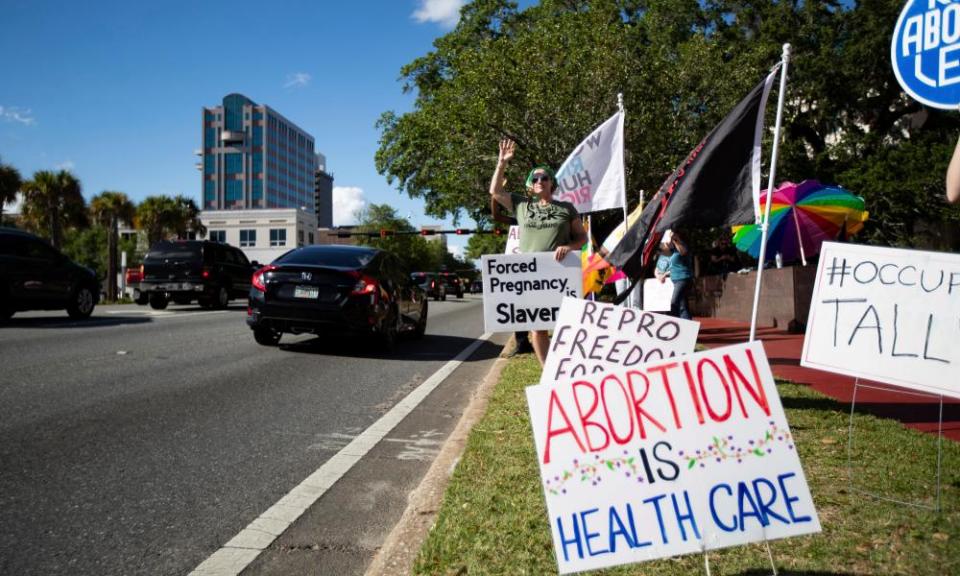 Las personas sostienen carteles durante una protesta contra la prohibición de abortos en Florida después de seis semanas