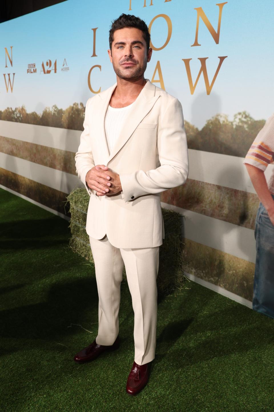 Zac Efron, suits, suiting, loafers, brogues, shoes, footwear, menswear, men's style, celebrity style, celebrity red carpet, red carpet, premiere, A24, The Iron Claw, Reiss, suit, cream suit