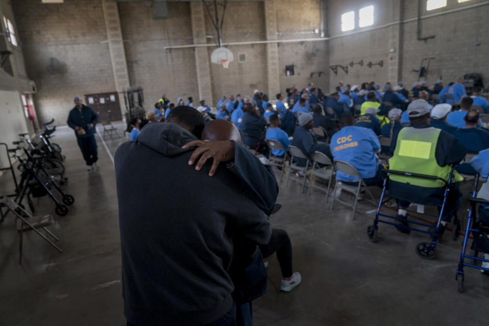 Filmmaker Sol Guy gets a hug from a prisoner during a screening of his personal documentary film, "The Death of My Two Fathers," at Valley State Prison's gymnasium in Chowchilla, Calif., Friday, Nov. 4, 2022. (AP Photo/Jae C. Hong)