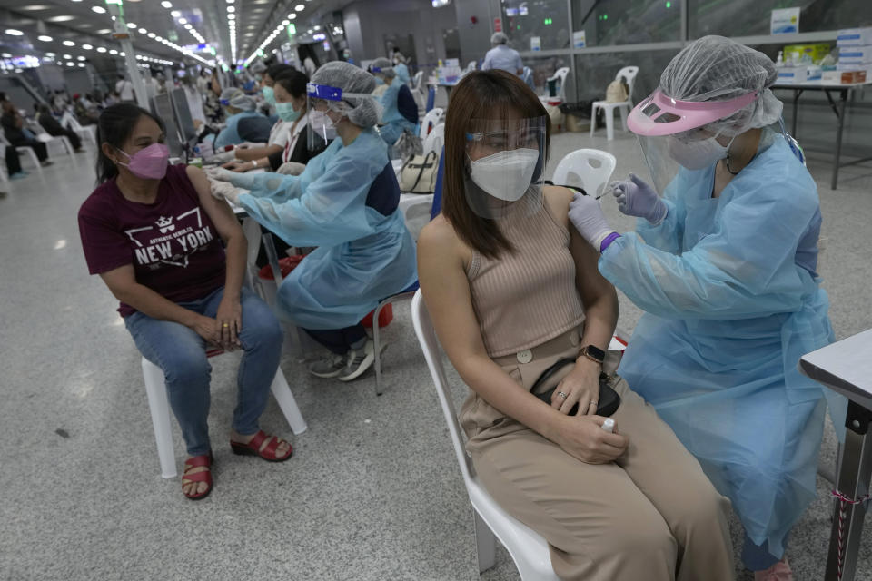 Health workers administer shots of the AstraZeneca COVID-19 vaccine at the Central Vaccination Center in Bangkok, Thailand, Thursday, July 15, 2021. As many Asian countries battle against a new surge of coronavirus infections, for many their first, the slow-flow of vaccine doses from around the world is finally picking up speed, giving hope that low inoculation rates can increase rapidly and help blunt the effect of the rapidly-spreading delta variant. (AP Photo/Sakchai Lalit)