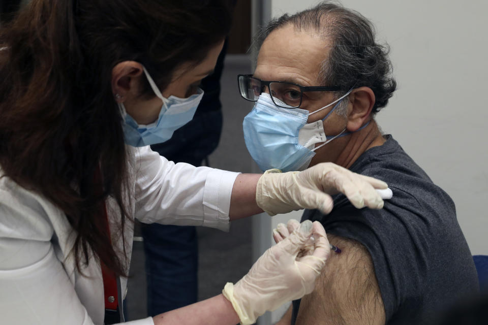 A healthcare worker receives Pfizer-BioNTech COVID-19 vaccine during a nationwide vaccination program at the American University Medical Center in Beirut, Lebanon, Sunday, Feb. 14, 2021. (AP Photo/Bilal Hussein)