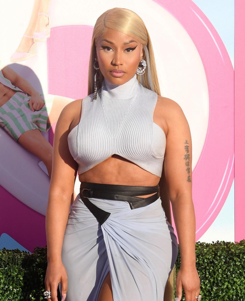 Close-up of Cardi at a media event in a knit, turtleneck crop top and wrap skirt