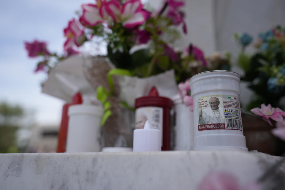 Candles with the image of Pope Francis are left at the entrance of the Agostino Gemelli University Polyclinic in Rome, Friday, June 9, 2023, where Francis is recovering after undergoing abdominal surgery on Wednesday. The Vatican says Pope Francis has had a second good night in the hospital recovering from surgery to remove intestinal scar tissue and repair a hernia in his abdominal wall.(AP Photo/Alessandra Tarantino)