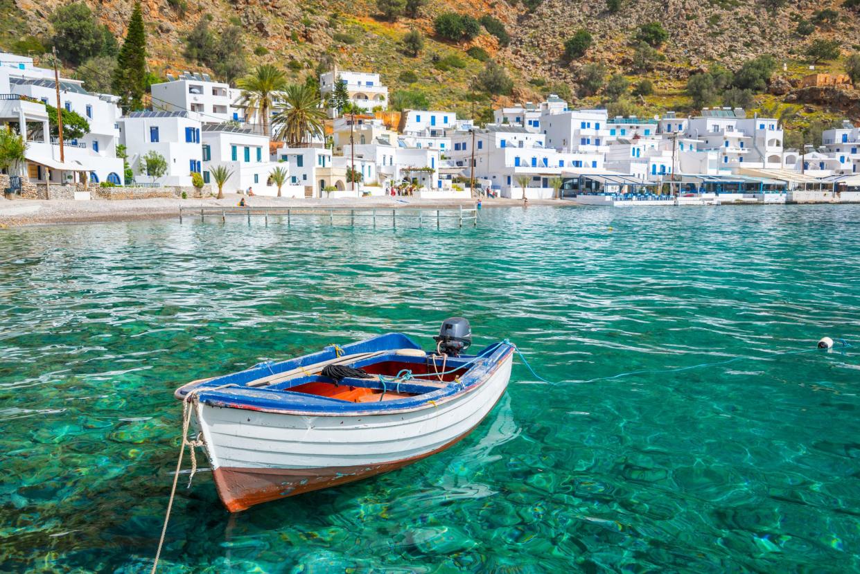 Fishing boat and the scenic village of Loutro in Crete, Greece