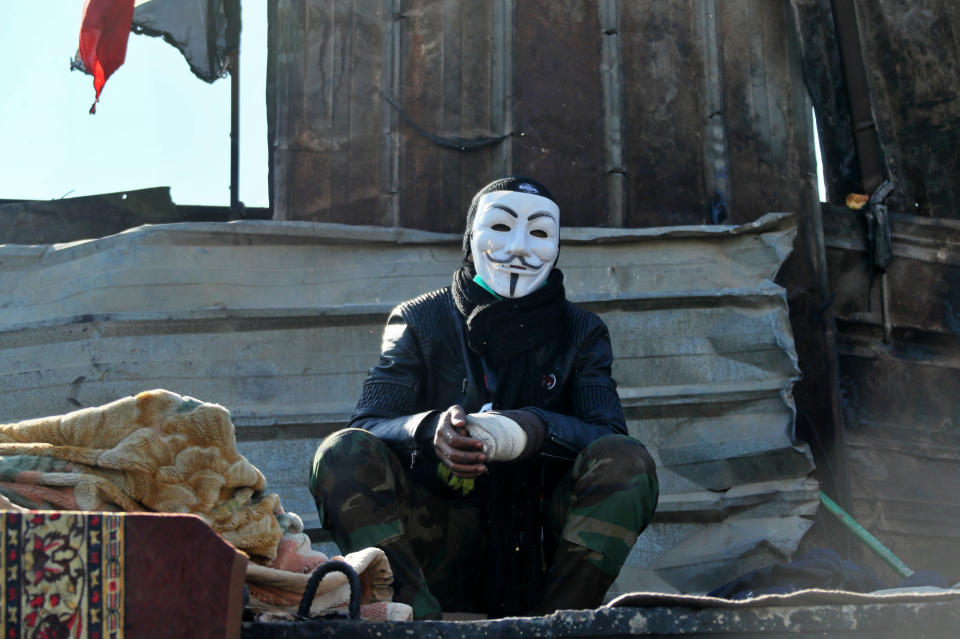 A protester wearing a Guy Fawkes mask takes part in a sit-in at the Ahrar Bridge in Baghdad, Iraq, Thursday, Nov. 21, 2019. Renewed clashes overnight in Baghdad between anti-government demonstrators and security forces killed and wounded protesters, security and hospital officials said Thursday. (AP Photo/Hadi Mizban)