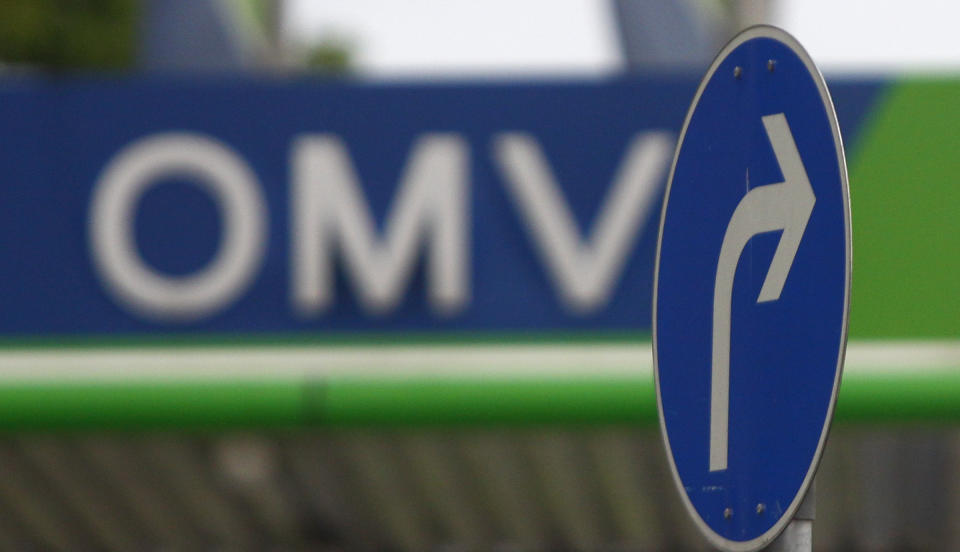 The logo of Austrian oil and gas group OMV is seen at a petrol station behind a road sign in Munich May 8, 2009. OMV reported a worse-than-expected 56 percent fall in clean operation earnings in the fourth quarter as the low oil price hit results. REUTERS/Dominic Ebenbichler (AUSTRIA BUSINESS ENERGY)