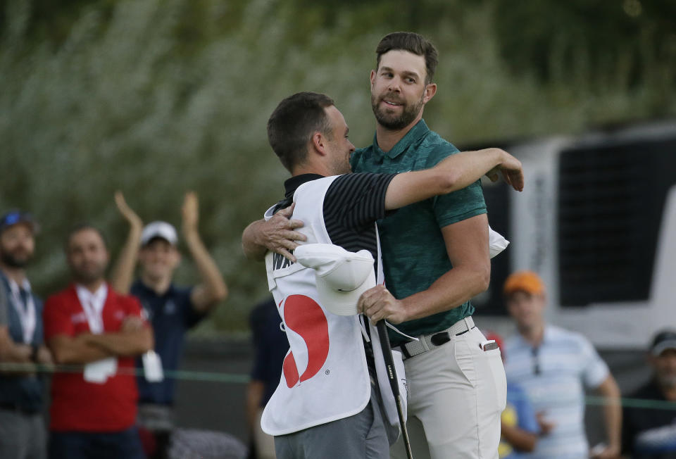 Kevin Tway is embraced by his caddie, Marc Sambol, left, after making a birdie putt on the third playoff hole to win the Safeway Open PGA golf tournament Sunday, Oct. 7, 2018, in Napa, Calif. (AP Photo/Eric Risberg)