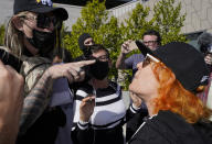 Critics, left, and supporters, right, of Dave Chappelle's Netflix special and its anti-transgender comments exchange words as they gathered outside the company's offices Wednesday, Oct. 20, 2021, with "Trans Lives Matter" and "Free Speech is a Right" among their competing messages. (AP Photo/Damian Dovarganes)