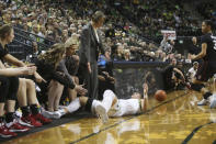 Oregon's Sabrina Ionescu falls, center, falls at the feet of Stanford coach Tara Vanderveer while diving for a loose ball during the second quarter of an NCAA college basketball game in Eugene, Ore., Thursday, Jan. 16, 2020. (AP Photo/Chris Pietsch)