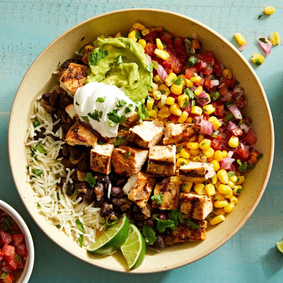 copycat chipotle burrito bowl with chicken, guacamole, corn salsa, black beans, and cilantro lime rice