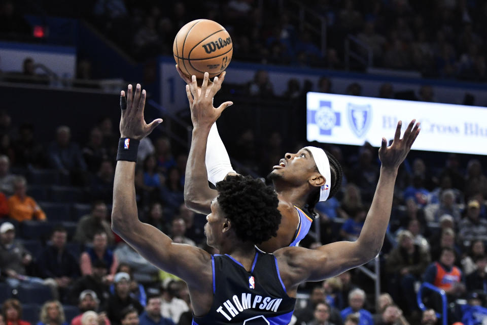 Oklahoma City Thunder guard Shai Gilgeous-Alexander, right, shoots over Detroit Pistons forward Ausar Thompson in the first half of an NBA basketball game, Monday, Oct. 30, 2023, in Oklahoma City. (AP Photo/Kyle Phillips)