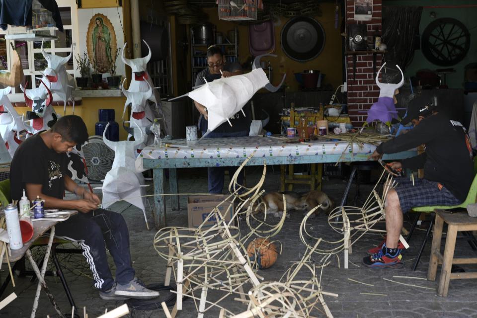 Members of the Cortes Miranda family construct paper-mache bulls that will be stuffed with fireworks, in preparation for the annual festival in honor of Saint John of God, the patron saint of the poor and sick whom fireworks producers view as a protective figure, in Tultepec, Mexico, Tuesday, March 5, 2024. (AP Photo/Marco Ugarte)