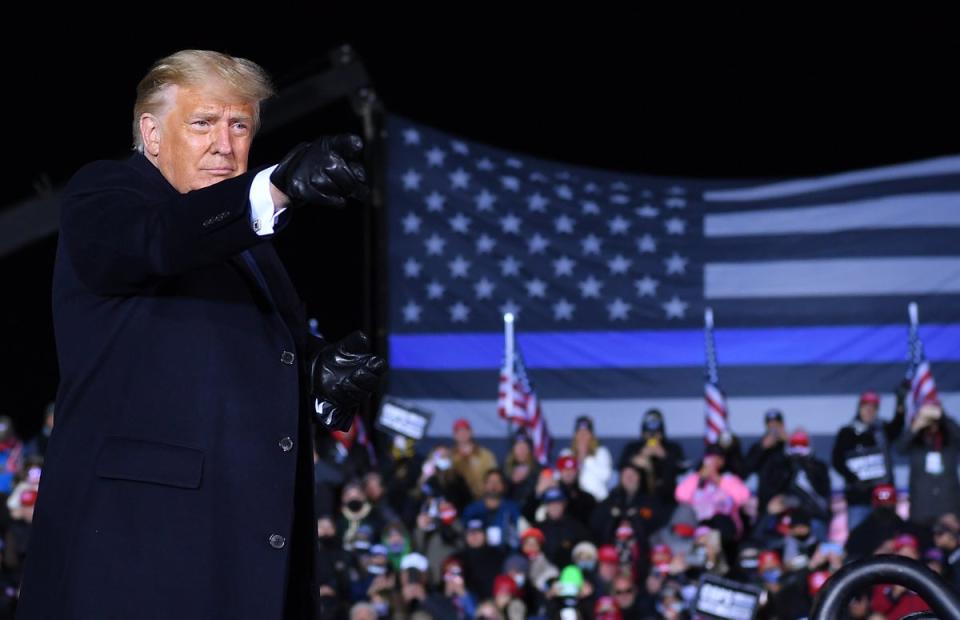 Donald Trump speaks in front of a thin blue line flag at a 2020 rally (AFP via Getty Images)