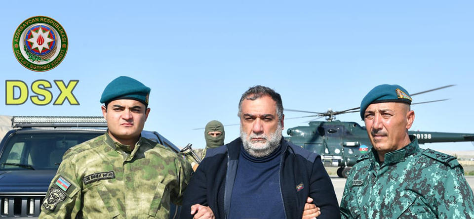 In this photo released by Azerbaijan's border guard service on Wednesday, Sept. 27, 2023, Azerbaijan's border guard officers pose with detained Ruben Vardanyan, center, in Nagorno-Karabakh. Azerbaijan says it has detained the former head of Nagorno-Karabakh's separatist government as he tried to cross into Armenia following Azerbaijan's 24-hour blitz last week to reclaim control of the enclave. The arrest of Ruben Vardanyan was announced by Azerbaijan's border guard service. (Azerbaijan's border guard service via AP)