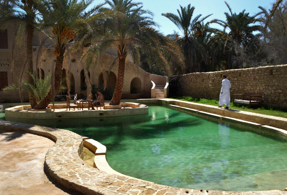 This September 2012 photo shows people by a freshwater pool at the Ghaliet Ecolodge and Spa in the Egyptian oasis of Siwa, a Berber town of some 27,000 people roughly 450 miles (about 725 kilometers) southwest of Cairo. The palm tree-lined area is known for its quiet charm, ancient ruins, abundant natural springs, a vast salt lake and rolling sand dunes in the surrounding desert. (AP Photo/Kim Gamel)