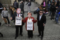 People wear masks of US President Donald Trump and German Chancellor Angela Merkel as they attend a 'Fridays For Future' rally at the Brandenburg Gate in Berlin, Germany, Friday, Sept. 20, 2019. Protests of the 'Fridays For Futurte' movement against the increase of carbon dioxide emissions take place Friday in cities around the globe. In the United States more than 800 events are planned Friday, while in Germany more than 400 rallies are expected. German slogan reads: 'Mom has missed it, youth has to do it now'. (AP Photo/Markus Schreiber)