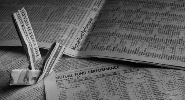 B4MHX8 Mutual Funds are displayed on a newspaper with a five dollar bill in the shape of an arrow pointing towards the mutual fu