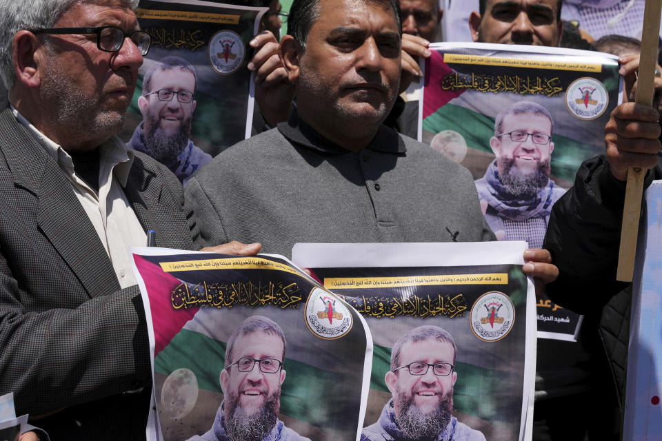 Palestinians hold pictures of Khader Adnan, a leader in the militant Islamic Jihad group, who died in Israeli prison after a nearly three-month hunger strike, during a sit-in in front of the International Committee of the Red Cross office, in Gaza City, Tuesday, May 2, 2023. Adnan had begun staging protracted hunger strikes more than a decade ago, introducing a new form of protests against Israel's mass detentions of Palestinians without charges or trials. On Tuesday, the 45-year-old became the first long-term hunger striker to die in Israeli custody. (AP Photo/Adel Hana)