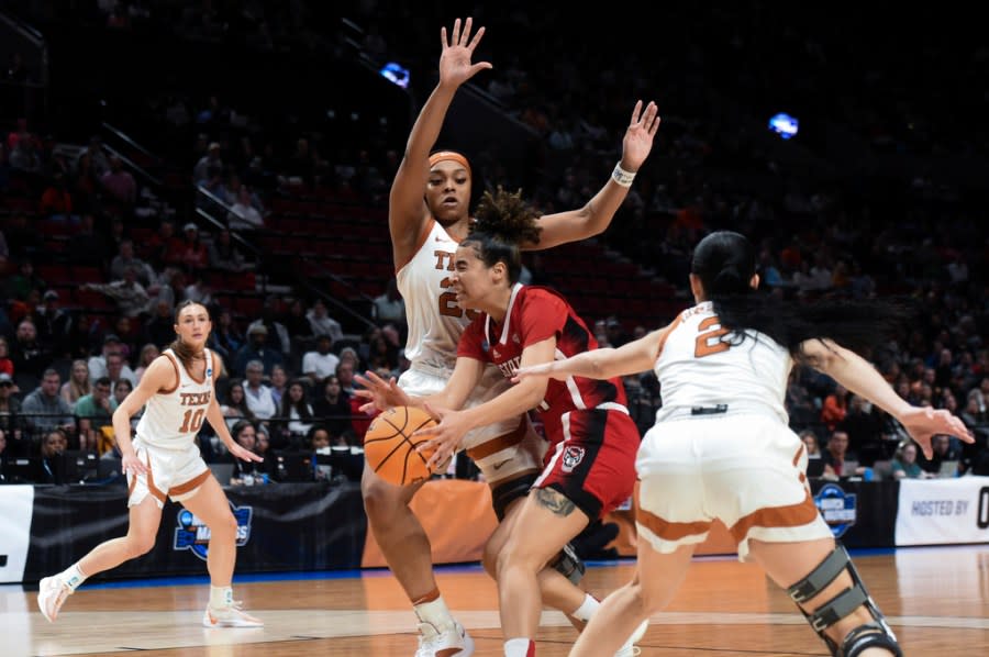 North Carolina State guard Madison Hayes, second from right, drives to the basket as Texas forward Aaliyah Moore and guard Shaylee Gonzales (2) defend during the first half of an Elite Eight college basketball game in the women’s NCAA Tournament, Sunday, March 31, 2024, in Portland, Ore. (AP Photo/Steve Dykes)