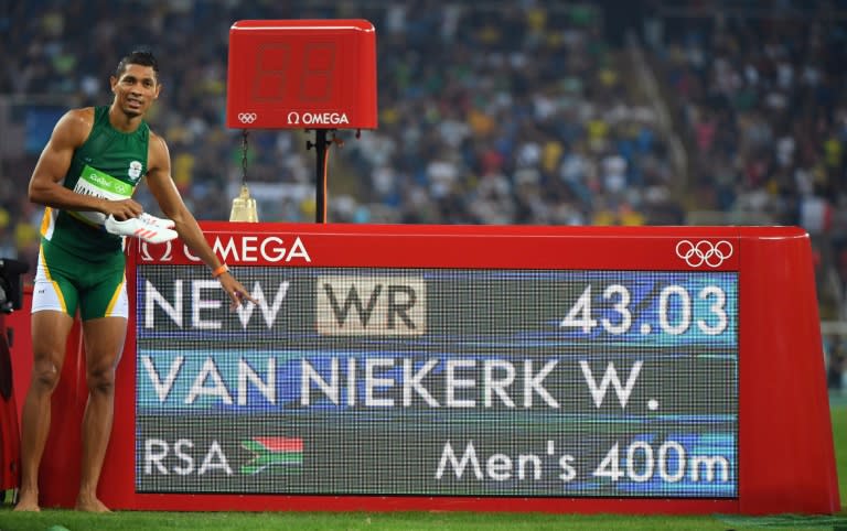 South Africa's Wayde van Niekerk poses by the results board after he broke the world record to win the 400m at the 2016 Olympic Games in Rio de Janeiro