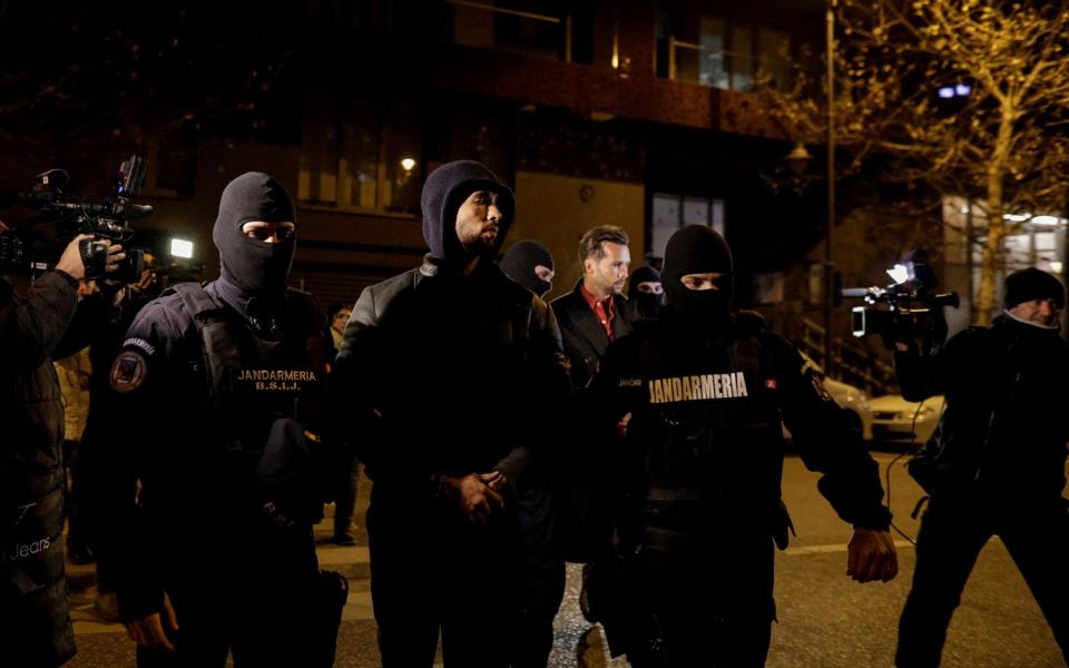 Andrew Tate and Tristan Tate are escorted by police officers outside the headquarters of the Directorate for Investigating Organized Crime and Terrorism in Bucharest - Reuters